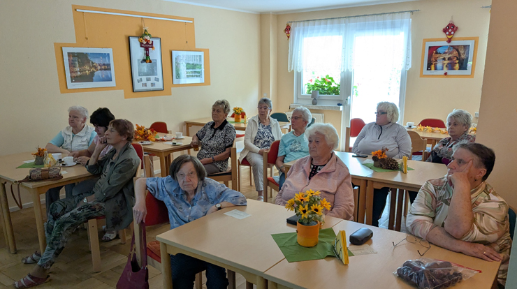 Eine Gruppe Frauen hört dem Bildervortrag von Harald Lasch zu.
